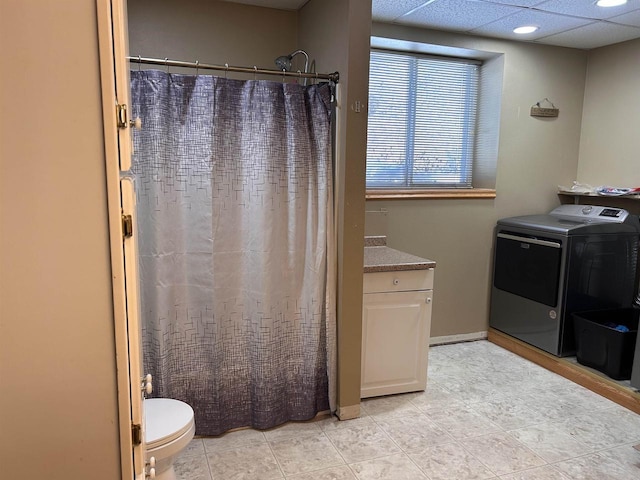 bathroom with washer / dryer, baseboards, a drop ceiling, toilet, and a shower with curtain