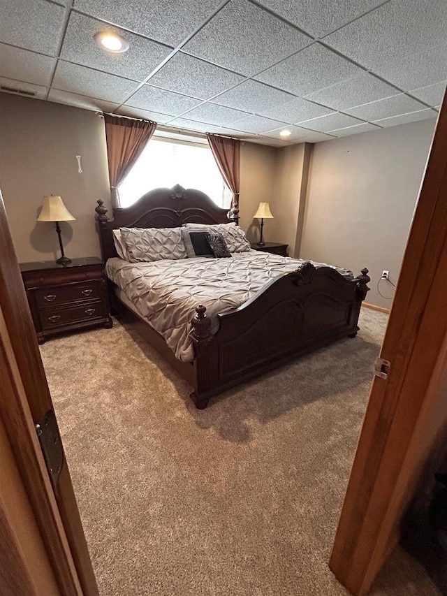 bedroom featuring light carpet, a drop ceiling, and recessed lighting