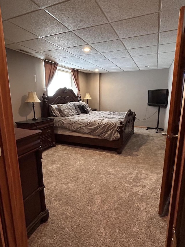 carpeted bedroom with a drop ceiling