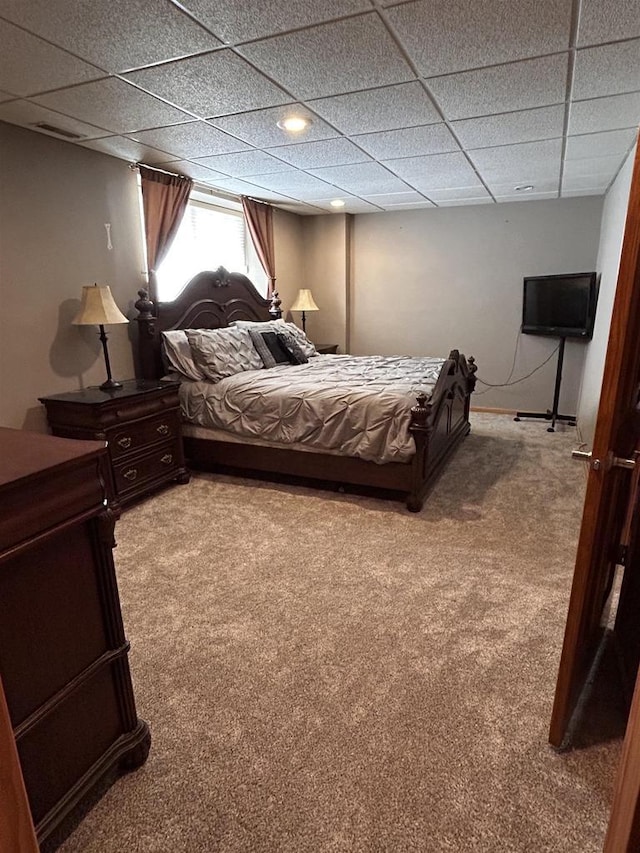 bedroom with carpet floors and a drop ceiling