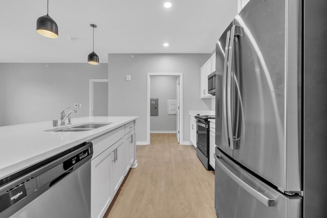 kitchen with stainless steel appliances, hanging light fixtures, a sink, and white cabinets