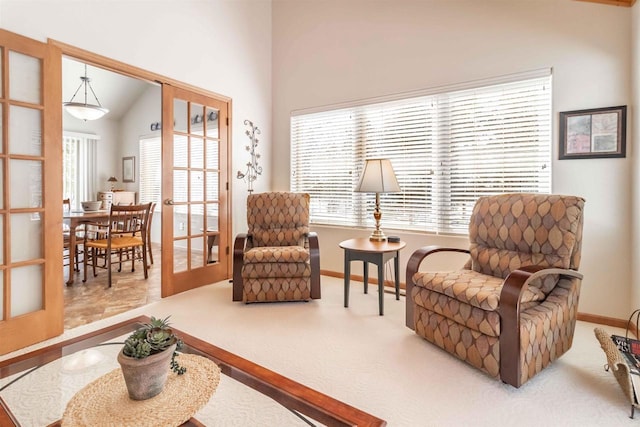 sitting room with carpet floors, plenty of natural light, baseboards, and french doors