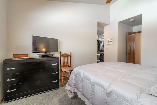 bedroom featuring carpet floors, a closet, a spacious closet, and a ceiling fan