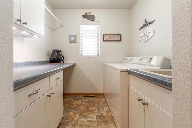 laundry room with stone finish flooring, cabinet space, washer and clothes dryer, and baseboards