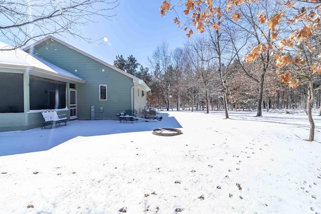 yard layered in snow with a sunroom