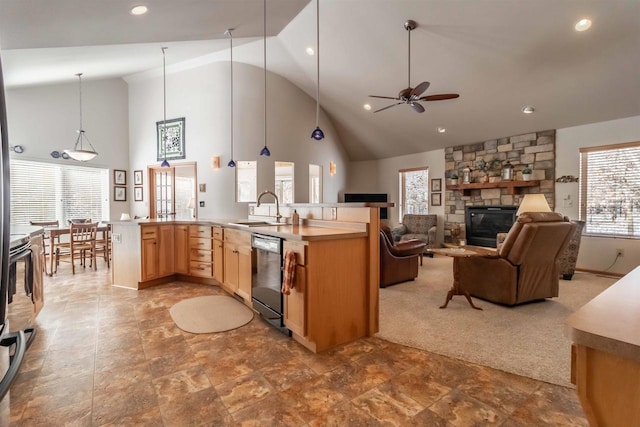 kitchen with light brown cabinetry, open floor plan, a sink, a stone fireplace, and dishwasher