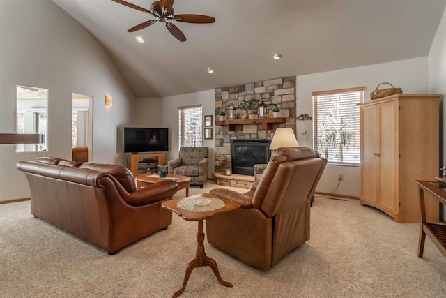 living area with light carpet, ceiling fan, a stone fireplace, high vaulted ceiling, and baseboards