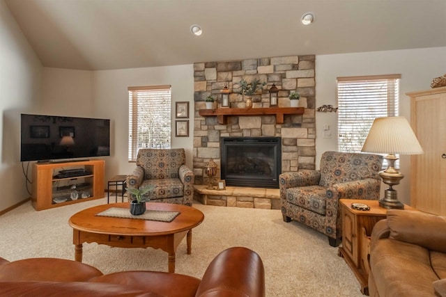 living area featuring lofted ceiling, carpet flooring, and a stone fireplace