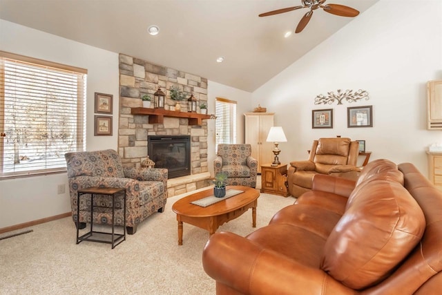 living room featuring light carpet, a stone fireplace, baseboards, and a healthy amount of sunlight