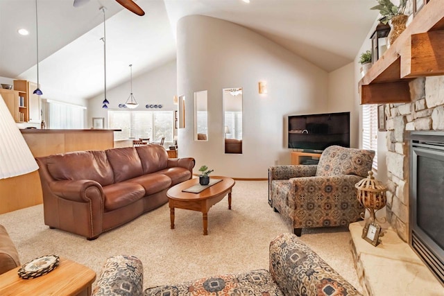 carpeted living room featuring plenty of natural light, a fireplace, high vaulted ceiling, and a ceiling fan