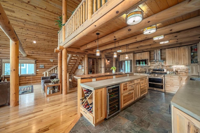 kitchen featuring beverage cooler, wooden ceiling, wall chimney exhaust hood, open floor plan, and stainless steel appliances