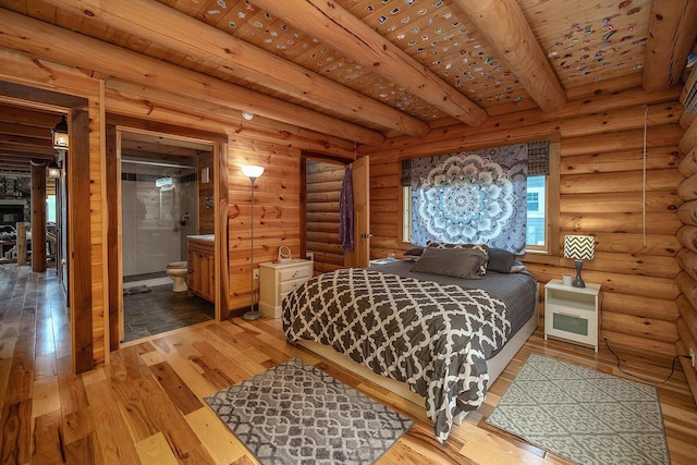 bedroom featuring light wood-style flooring, wood ceiling, log walls, beamed ceiling, and ensuite bath