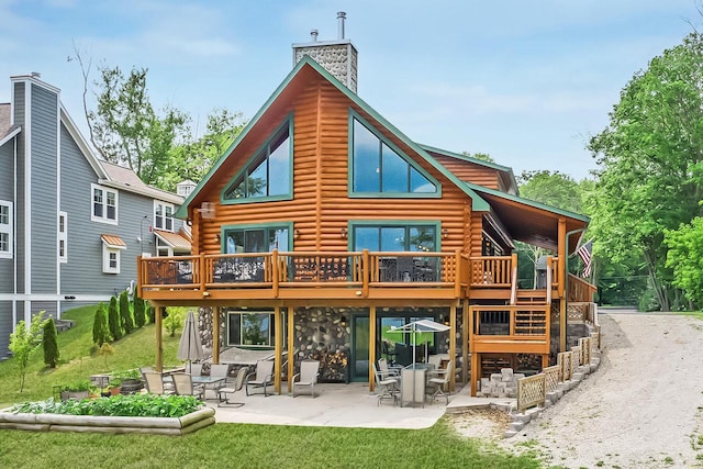 back of property with a chimney, a deck, log exterior, and a patio