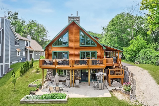 back of property featuring a wooden deck, a chimney, log exterior, and a patio