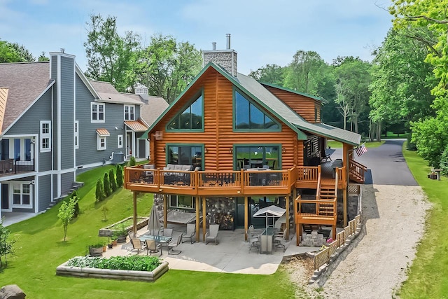 back of property with a chimney, log exterior, and a patio