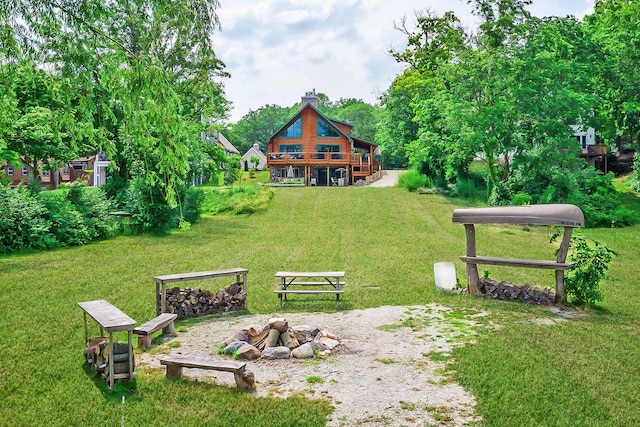 exterior space with an outdoor fire pit and a yard