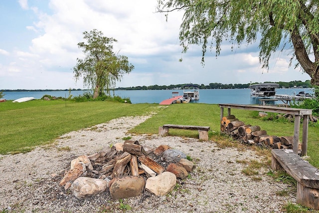 view of yard featuring a dock, a water view, and boat lift