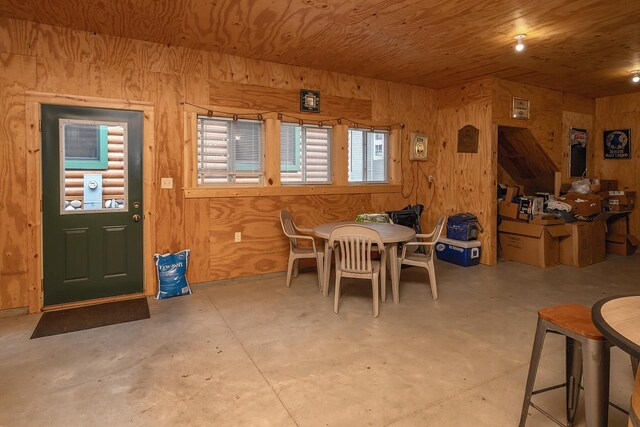 dining space with wood ceiling and concrete floors