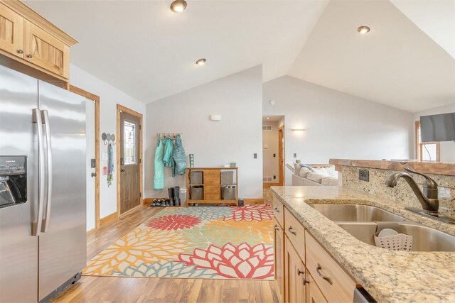 W5611 32nd St, New Lisbon, WI 53950 - kitchen with vaulted ceiling, light brown cabinetry, light wood-type flooring, stainless steel refrigerator with ice dispenser, and a sink