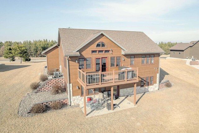 W5611 32nd St, New Lisbon, WI 53950 - rear view of property featuring a shingled roof, a patio, and a wooden deck