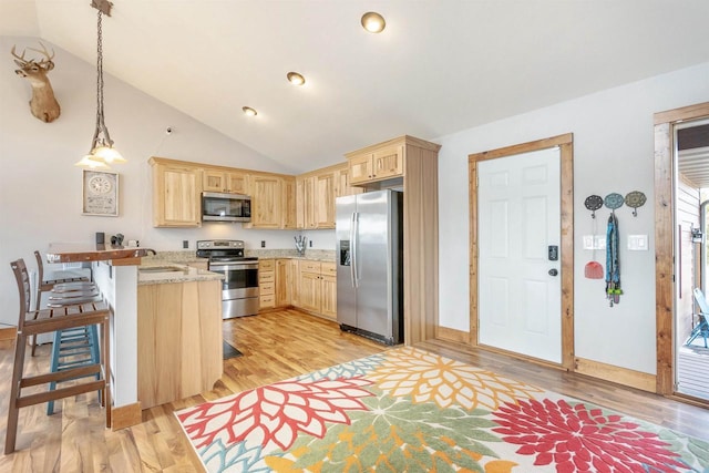 W5611 32nd St, New Lisbon, WI 53950 - kitchen featuring light brown cabinets, stainless steel appliances, a peninsula, light stone countertops, and light wood finished floors