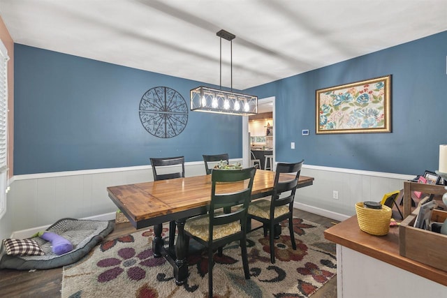 dining room with dark wood-style floors and wainscoting