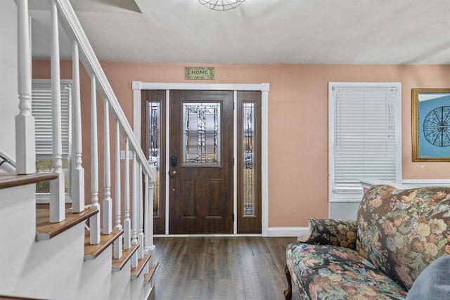 foyer with wood finished floors, baseboards, and stairs