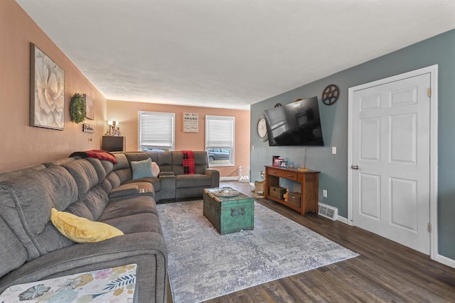 living room with dark wood-style floors, visible vents, and baseboards