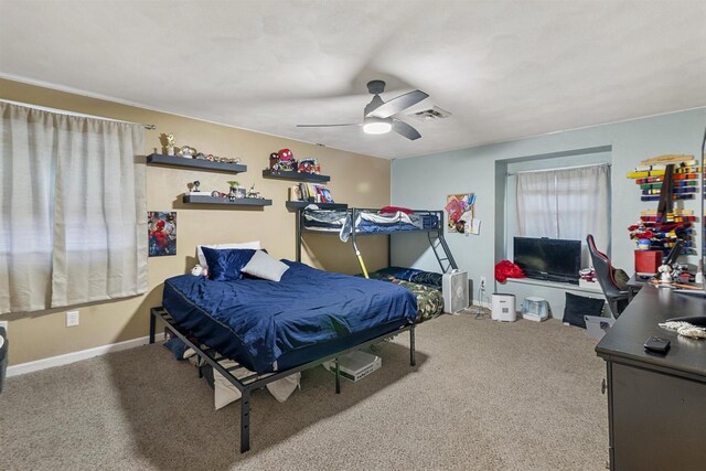 carpeted bedroom with a ceiling fan and visible vents