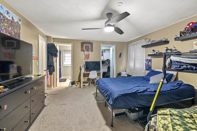 bedroom featuring a spacious closet, a closet, carpet flooring, and a ceiling fan