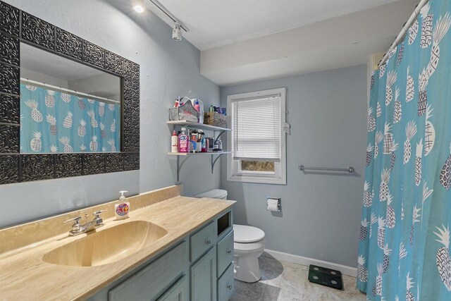 full bath with rail lighting, toilet, vanity, a shower with curtain, and baseboards