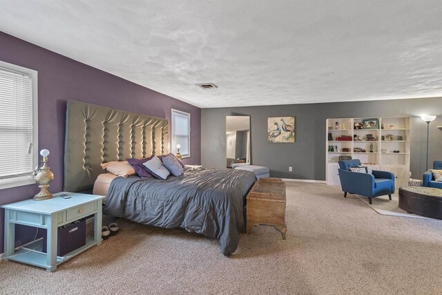 carpeted bedroom with visible vents, a textured ceiling, and baseboards