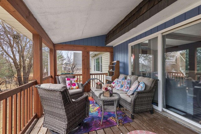 wooden terrace with an outdoor living space