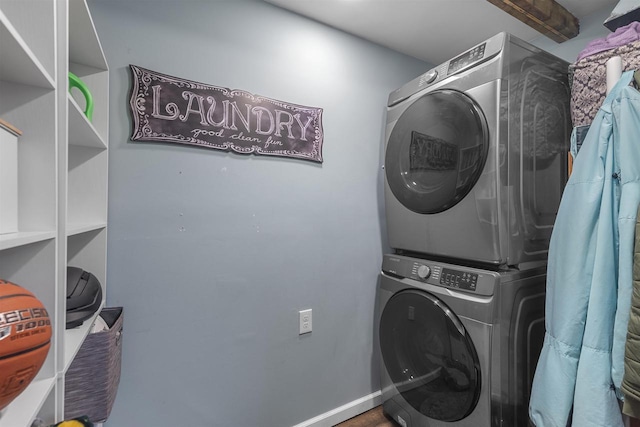 laundry room with laundry area, baseboards, and stacked washer and dryer
