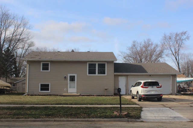 view of front of property featuring a front lawn, concrete driveway, and an attached garage