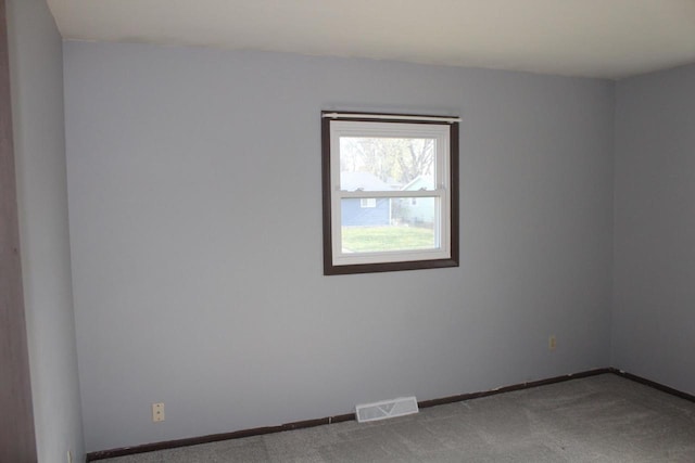 carpeted empty room featuring visible vents and baseboards