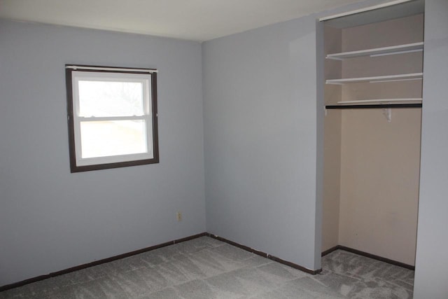 unfurnished bedroom featuring carpet floors, a closet, and baseboards