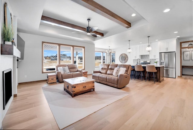 living area with recessed lighting, beam ceiling, light wood-style flooring, and baseboards