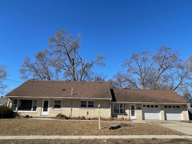 single story home with concrete driveway, brick siding, roof with shingles, and an attached garage