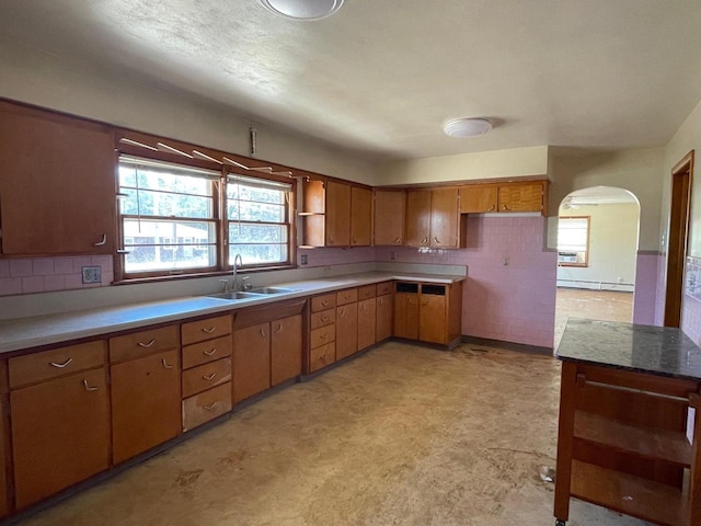 kitchen featuring open shelves, a baseboard radiator, a sink, and light countertops