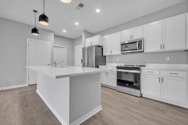 500 E Main St Unit 203, Waterford, WI 53185 - kitchen featuring stainless steel appliances, a sink, light wood-style flooring, and white cabinets