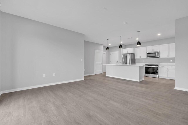 500 E Main St Unit 203, Waterford, WI 53185 - unfurnished living room with light wood-style floors, baseboards, and recessed lighting