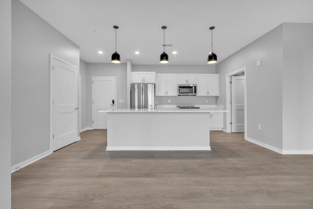 500 E Main St Unit 203, Waterford, WI 53185 - kitchen featuring baseboards, white cabinetry, stainless steel appliances, and light wood-style flooring