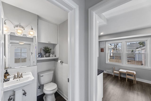 bathroom featuring toilet, baseboards, and wood finished floors