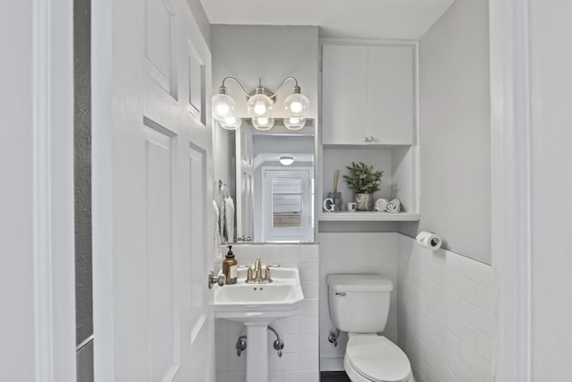 half bath featuring toilet and tile walls