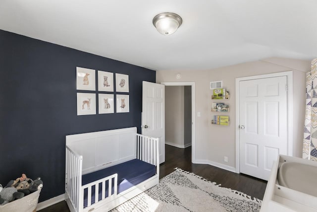 bedroom with dark wood finished floors, visible vents, and baseboards