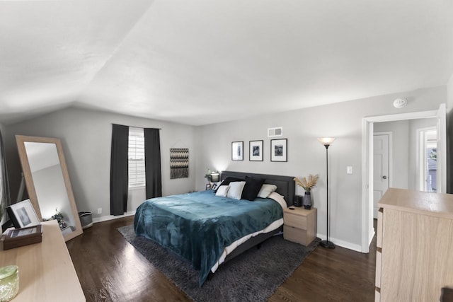 bedroom featuring visible vents, lofted ceiling, dark wood-type flooring, and baseboards