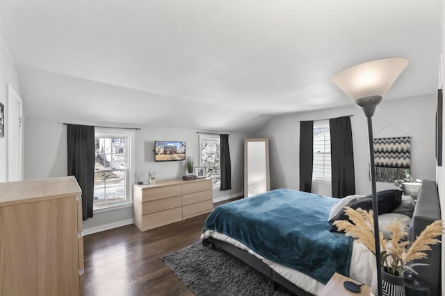 bedroom featuring baseboards, lofted ceiling, and dark wood finished floors