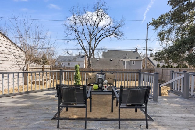 wooden terrace with a fenced backyard