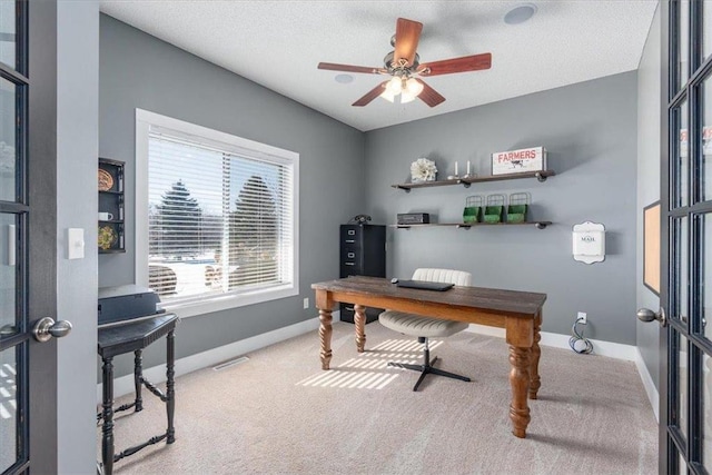 carpeted office space with a ceiling fan, french doors, a textured ceiling, and baseboards